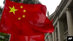 Bendera China dikibarkan oleh pendukung pro pemerintah di luar Pengadilan Banding Akhir di Hong Kong, Selasa 9 Februari 2021. (Vincent Yu/AP)