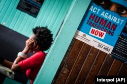 FILE - A prostitute is shown being questioned during a raid in night clubs in Georgetown, Guyana, April 7, 2018.