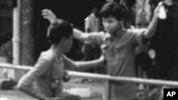 A Khmer Rouge rebel frisks a civilian in downtown Phnom Penh hours after the rebel forces led by Pol Pot took control of the Cambodian capital April 17, 1975.