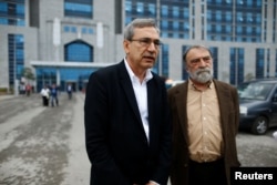 FILE - Turkish authors Orhan Pamuk, left, and Murat Belge leave Kartal Justice Palace after Belge appeared in court on charges of insulting Turkish President Tayyip Erdogan in Istanbul, May 3, 2016.