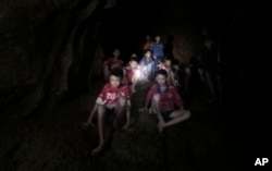 This July 2, 2018, photo released by Tham Luang Rescue Operation Center, shows the boys and their soccer coach as they were found in a partially flooded cave, in Mae Sai, Chiang Rai, Thailand.