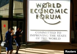 FILE - An attendee arrives in the Congress Hall during the World Economic Forum annual meeting in Davos, Switzerland Jan. 20, 2017.