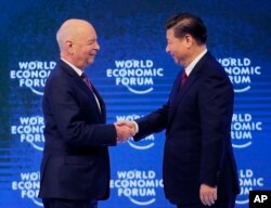 China's President Xi Jinping, right, is welcomed by World Economic Forum founder Klaus Schwab.