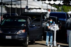 Para nakes menunggu di mobil untuk menjalani vaksinasi COVID-19 di San Diego, California (dok: AP/Gregory Bull)