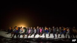 Refugees and migrants from many different African nationalities sit aboard an overcrowded rubber boat leaving Libyan territorial waters early March 5, 2017. A similar boat carrying more than 100 people sank off the coast of Libya earlier this week and dozens are missing.