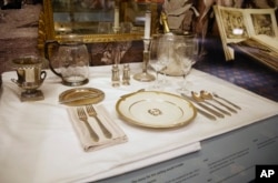 A place setting is displayed behind glass in the small museum off the lobby of New York's renowned Waldorf Astoria, Feb. 28, 2017. The newest version of the hotel opened on Park Avenue in 1931, built at a cost topping $40 million ($639 million in today's dollars).
