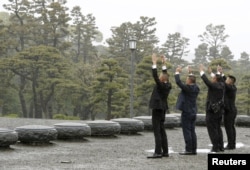 People raise hands as they shout 'banzai', or cheers, facing the Imperial Palace on the day of the Emperor Akihito's abdication in Tokyo, April 30, 2019.