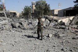 FILE - A police trooper walks on the rubble of a building destroyed by Saudi-led air strikes at Sana'a Airport in Sana'a, Yemen, Dec. 21, 2021.
