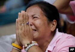 A woman prays for Thailand's King Bhumibol Adulyadej at Siriraj Hospital where the king is being treated in Bangkok, Thailand, Thursday, Oct. 13, 2016.