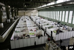 FILE - Cabins are set up inside Hanger 4 of the former airport Tempelhof to be used as a temporary emergency shelter for migrants, refugees and asylum seekers in Berlin on Dec. 9, 2015. Across Europe, gay, lesbian and transgender migrants say they suffer verbal and physical abuses.