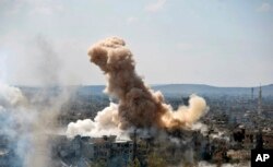 FILE - In this photo released by the Syrian official news agency SANA, smoke rises after Syrian government airstrikes and shelling hit in Hajar al-Aswad neighborhood held by Islamic State militants, southern Damascus, April 22, 2018.
