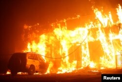 A structure is seen engulfed in flames during the Camp Fire in Paradise, California, U.S., Nov. 8, 2018.