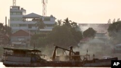 In this 2010 photo, a private boat dredges sand in the Mekong river near Phnom Penh, Cambodia.
