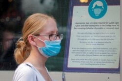 Seorang pengunjung mengenakan masker untuk melindungi dari penularanCOVID-19 menyusul rekomendasi CDC, di sebuah Disney Store.