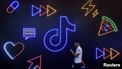 Seorang pria melintas di depan logo aplikasi TikTok buatan perusahaan China, ByteDance, di Hangzhou, Provinsi Zhejiang, China, 18 Oktober 2019. 