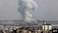 A smoke plume erupts over Khan Yunis from Rafah in the southern Gaza strip during Israeli bombardment on Dec. 27, 2023, amid continuing battles between Israel and the Palestinian Hamas militant group.