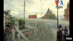 ប៉ូលិស​ប្រើកាណុង​បាញ់​ទឹក​បំបែក​ហ្វូង​បាតុករ​នៅ​មុខ​វត្ត​ឧណ្ណាលោម ភ្នំពេញថ្ងៃ​អាទិត្យ​ទី​១៥​កញ្ញា​២០១៣។ 
