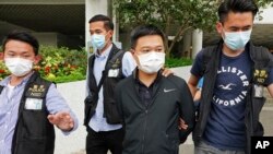 Ryan Law, second from right, Apple Daily's chief editor, is arrested by police officers in Hong Kong Thursday, June 17, 2021. (AP Photo)