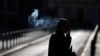 A man smokes a cigarette as he walks early morning in Frankfurt, Germany, Sept. 8, 2020.
