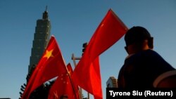 Pendukung Pro-China mengibarkan bendera nasional China di depan gedung landmark Taipei 101, di Taipei, Taiwan 22 Agustus 2016. (Foto: REUTERS/Tyrone Siu)