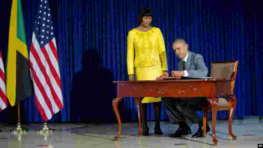 Le président Barack Obama, accompagné par le Premier ministre jamaïcain Portia Simpson-Miller, signe le livre d'or avant leur rencontre bilatérale à la Maison de la Jamaïque, le jeudi 9 Avril, 2015 Kingston, en Jamaïque.