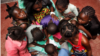 Children gather around a table at SOS Children's Villages Bangui. (Photo by Till Müllenmeister)