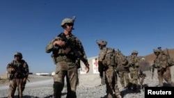 FILE - U.S. troops wait for their helicopter at an Afghan National Army (ANA) base in Logar province, Afghanistan, Aug. 7, 2018.