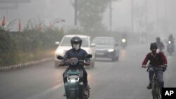 Commuters drive through a thick layer of smog as air pollution shoots up in New Delhi, Nov. 18, 2024.
