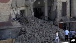 Egyptian policemen stand at the base of the crumbled facade of the Italian consulate following a blast that killed at least one person in Cairo, Egypt, July 11, 2015. 
