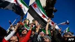TOPSHOT - Syrian residents in Turkey wave Syrian opposition flags as they celebrate the fall of long-time ruler Bashar al-Assad after rebel fighters took control of the Syrian capital Damascus overnight, in Istanbul on December 8, 2024.