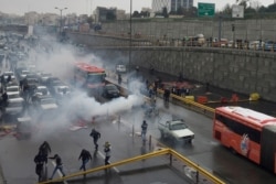 Riot police try to disperse protesters as they rally on a highway against increased fuel prices, in Tehran, Iran, Nov. 16, 2019.