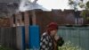 An elderly local woman passes a house destroyed by shelling in Semyonovka, a town near Slovyansk, Ukraine, on May 23, 2014. 
