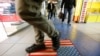 FILE - A man steps on a doormat depicting a U.S. flag, inside a shopping center in Moscow, Russia, Dec. 25, 2014.
