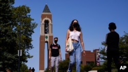 Masked students walk through the campus of Ball State University in Muncie, Ind., Sept. 10, 2020. 