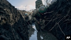 Українські солдати в окопі під обстрілом Росії на лінії фронту поблизу Бахмута, 5 березня 2023. (AP Photo/Libkos, файл)