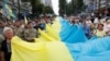 На фото: учасники Маршу захисників України у Києві з прапором, серпень 2020