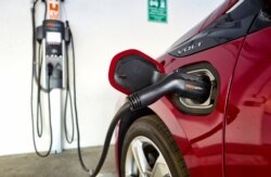 FILE - A Chevrolet Volt hybrid car is hooked up at a ChargePoint charging station at a parking garage in Los Angeles, Oct. 17, 2018.