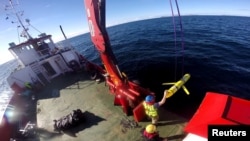 FILE - Crew members aboard the VOS Raasay recover U.S. and British Royal Navy ocean gliders taking part in the Unmanned Warrior exercise off the northwest coast of Scotland. A similar unmanned underwater vehicle was seized by the Chinese Navy in international waters off the coast of the Philippines.