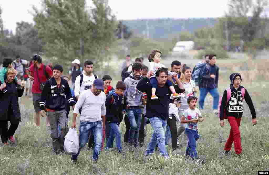 Migrants walk away from the border crossing from Hungary in Nickelsdorf, Austria. Austria announced it would dispatch the armed forces to guard its eastern frontier, following Germany's lead in reimposing Europe's internal border controls after thousands of migrants streamed across its frontier from Hungary on foot.