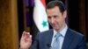 FILE - In this Feb. 10, 2015 photo released by the Syrian official news agency SANA, Syrian President Bashar Assad gestures during an interview with the BBC, in Damascus.