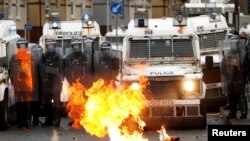 Polisi siaga di dekat kebakaran, pada saat terjadi kekerasan massa di Belfast, Irlandia Utara (8/4) lalu (foto: dok). 