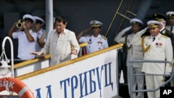 Angkatan Laut Rusia dan seorang perwira Filipina memberi hormat saat Presiden Filipina Rodrigo Duterte turun dari Kapal anti-kapal selam Laksamana Tributs milik Angkatan Laut Rusia di Manila, Filipina, 6 Januari 2017. (AP Photo/Aaron Favila).
