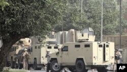 Private security personnel stand guard at the site of a bomb attack in Baghdad June 6, 2011.