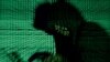 FILE - A man holds a laptop computer as cyber code is projected on him in this photo illustration.