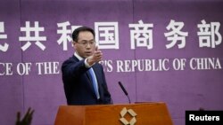 Chinese Ministry of Commerce spokesman Gao Feng gestures as journalists raise hands for questions during a press conference at the Ministry of Commerce in Beijing, April 6, 2018. 