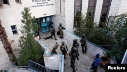 Petugas keamanan Israel memeriksa daerah sekitar sebuah sinagoga di Yerusalem pasca serangan dua warga Palestina (18/11). Dilaporkan empat orang tewas dalam serangan tersebut.