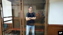 Reporter Wall Street Journal Evan Gershkovich berdiri di dalam sangkar kaca di ruang sidang Pengadilan Kota Moskow di Moskow, Rusia, Kamis, 22 Juni 2023. (AP/Dmitry Serebryakov)