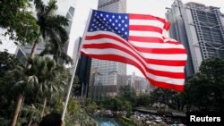 Seorang pria memegang bendera AS ketika pengunjuk rasa pro-demokrasi berkumpul di Chater Garden sebelum pawai untuk memprotes kekerasan polisi di Hong Kong, 28 Juli 2019. (Foto: dok).