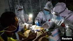 Petugas medis mengambil sampel rapid test dari pedagang di pasar tradisional untuk mencegah penyebaran virus Covid-19 di Semarang, Jawa Tengah, 22 Mei 2020. (Antara Foto/Aji Styawan/ via REUTERS)