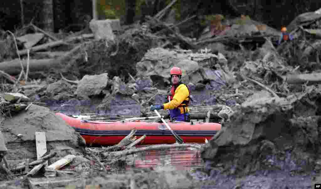 Anggota team SAR melakukan pencarian korban yang hilang dalam bencana tanah longsor di Oso, negaara bagian Washington, AS.&nbsp;